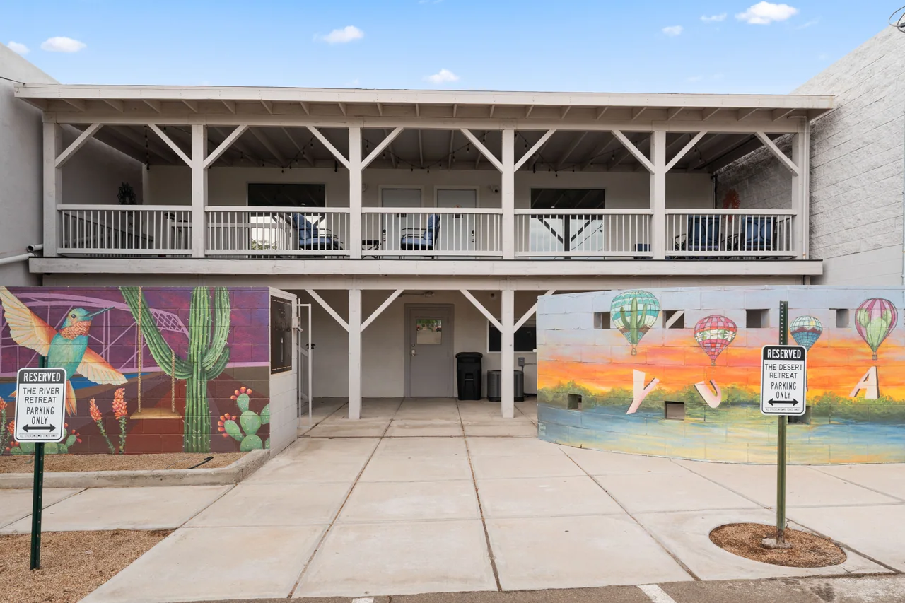 The back of the building: a hummingbird and cactus mural on the left, hot-air balloons spelling YUMA on the right, and the covered deck upstairs