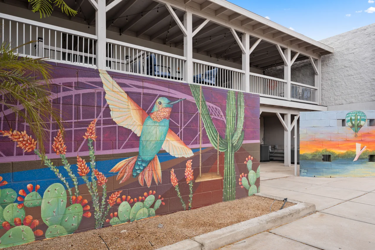 The hummingbird and cactus mural painted on the back of The Retreats building