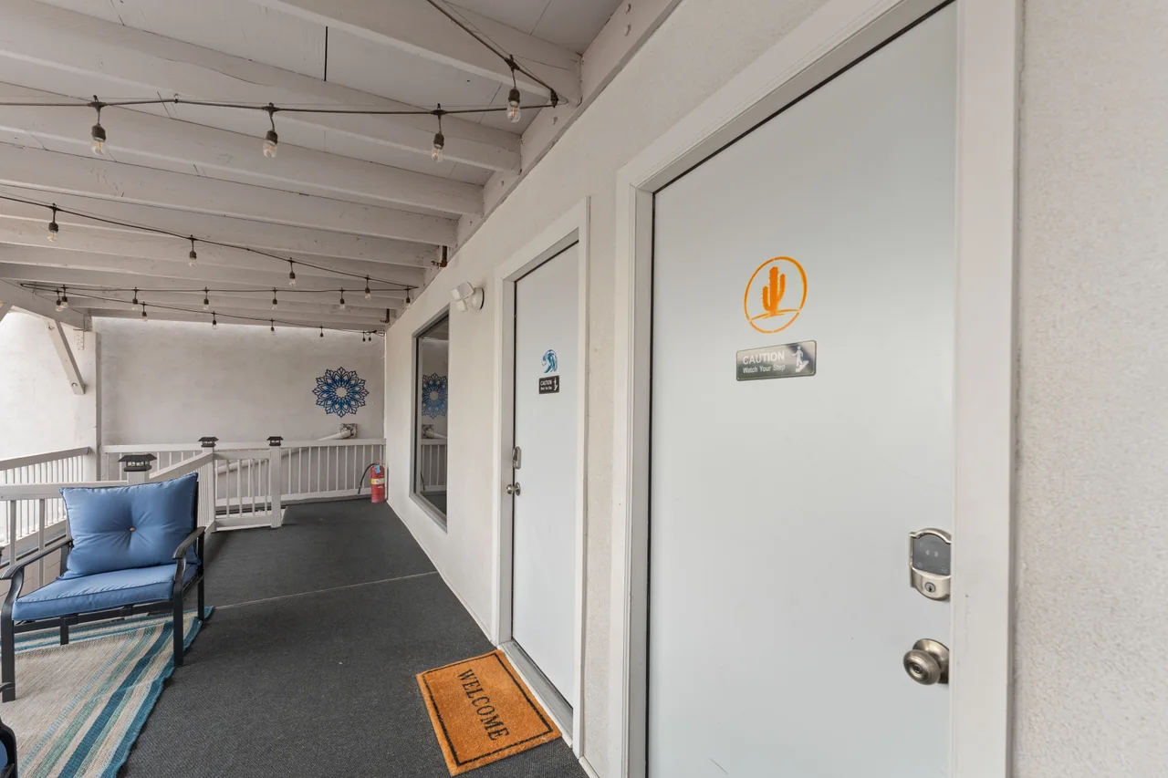 The Desert Retreat door with an orange cactus marker on the shared deck