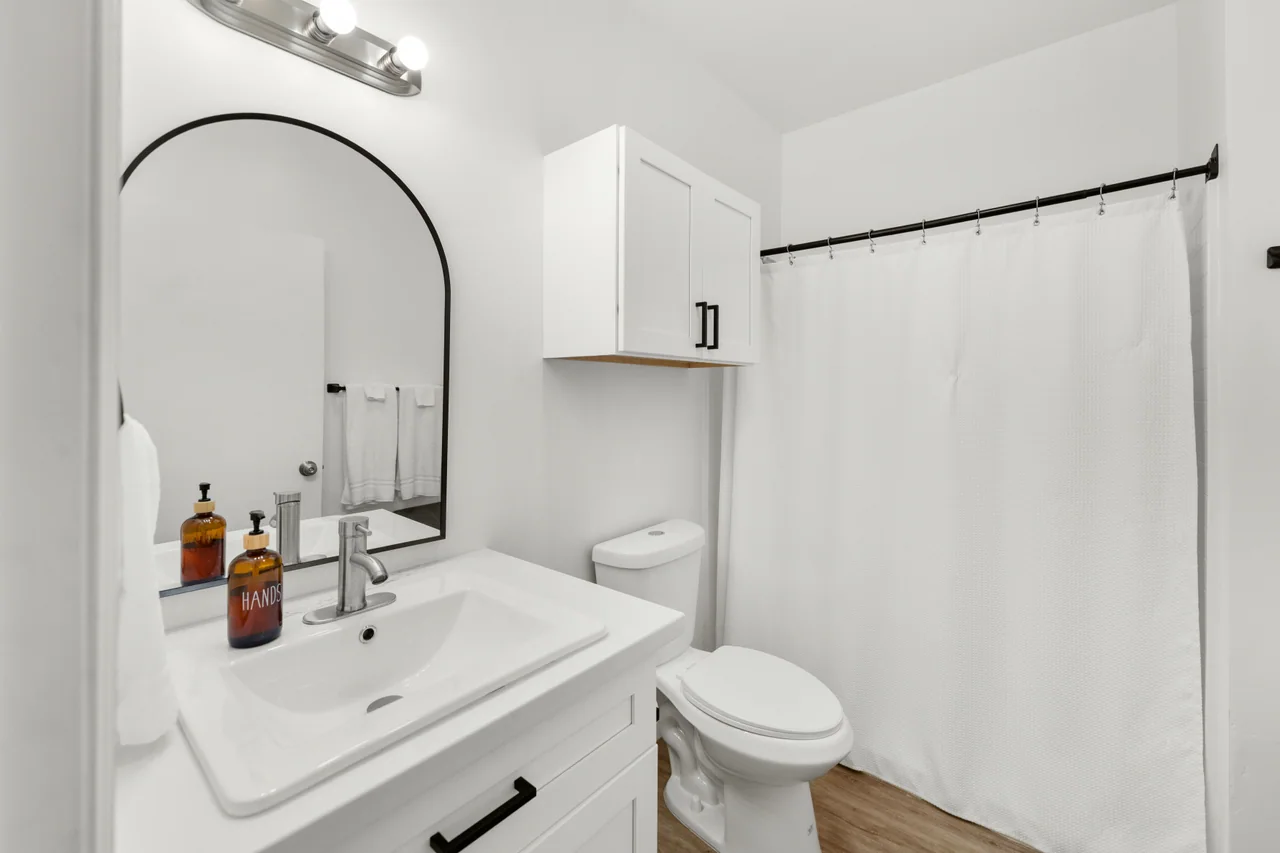 Bathroom with vanity, mirror and shower curtain