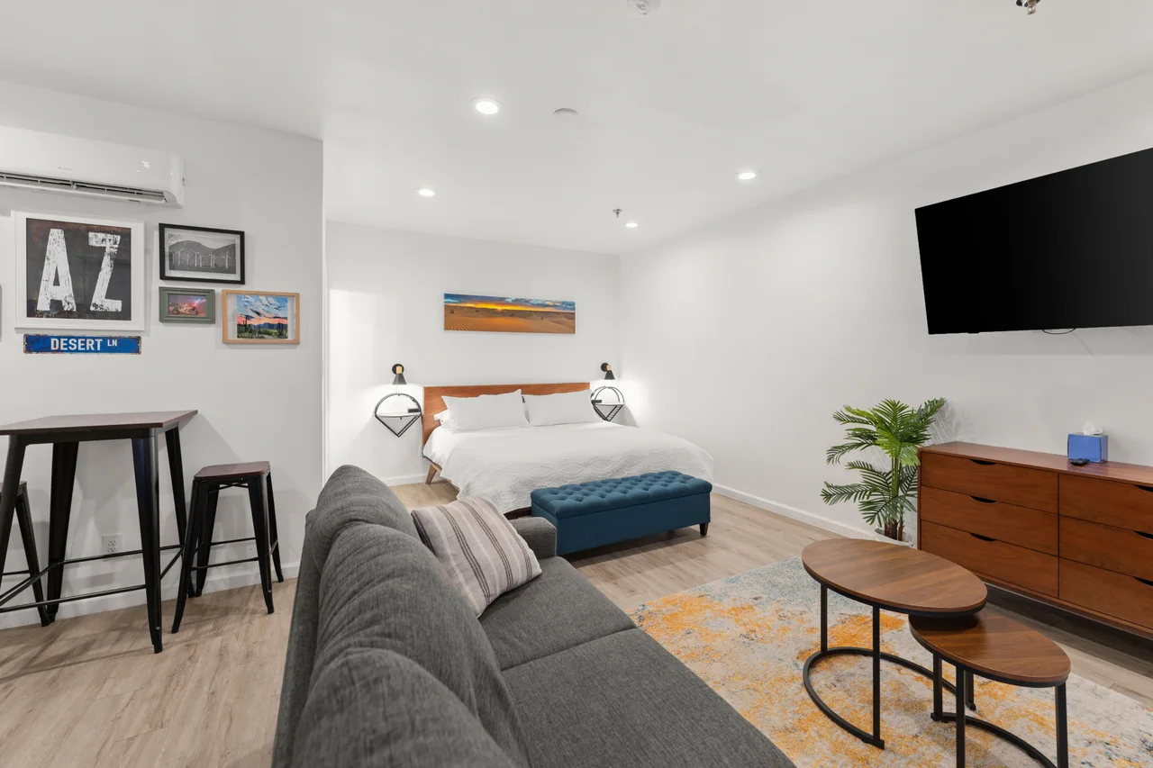 The Desert Retreat studio with a king bed, sofa and Arizona artwork